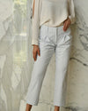Model wearing standing in front of white marble wall while wearing Cropped Seersucker Pant. 