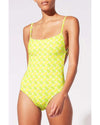 Model wearing bright yellow one-piece swimsuit with pineapple tile.