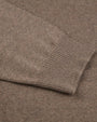 A close-up view of brown fabric with a ribbed wrist cuff laid on top.