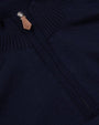A close-up view of a navy sweaters' neckline cuff with a brown leather zipper handle.