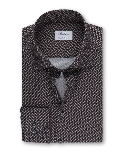 An overhead view of a folded button-down shirt featuring a small, intricate geometric pattern, and a chest pocket with two buttons. The shirt has a white square label inside the collar that reads "Stenströms" and 'Crafted to perfection.