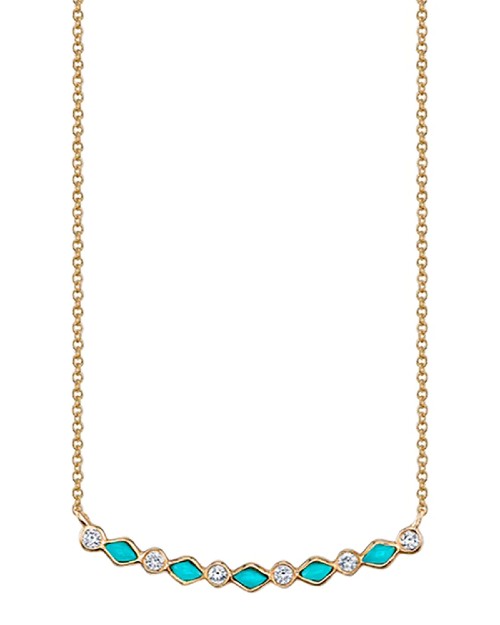 Gold chain with turquoise and diamond curved bar in front of white background.
