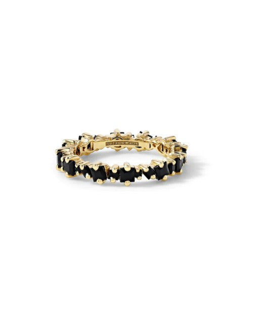 Gold band ring with black sapphires in front of white background.