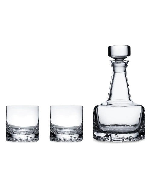 Decanter and glasses in front of all white background.