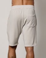 Back view of model wearing Atlas Luxe Fleece Shorts showing one back pocket on right side. 