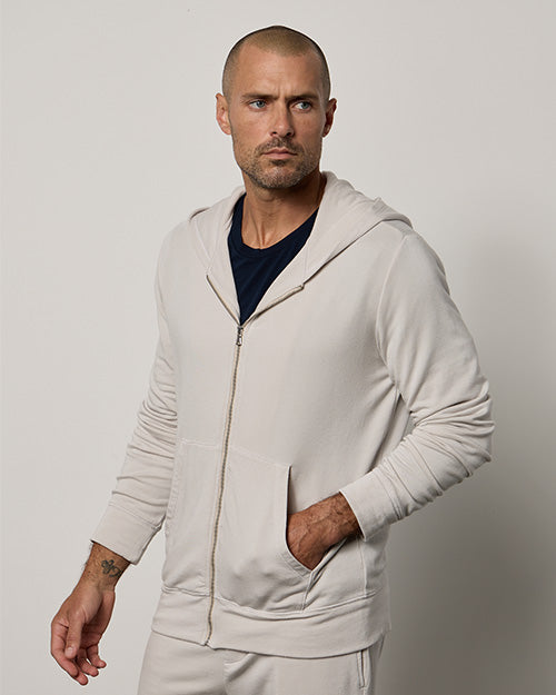 Model wearing cream-colored zip hoodie with shorts and black tee underneath.